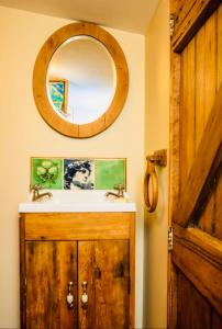 a bathroom with a sink and a mirror on the wall at Rustic cabin with hot tub - Homewood Forest Retreat in Alexandra