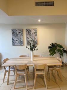a dining room table with chairs and a plant at Robin Beach Hostel JBR in Dubai