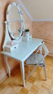 a dressing table with a mirror and a chair at Family apartment 'Sofia' in Brežice +33 photos