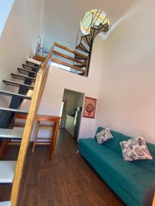 a living room with a green couch and stairs at Verano Azul Loft in Puerto López