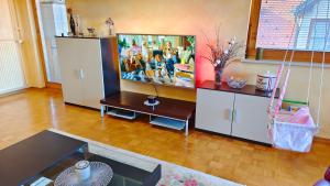 a living room with a flat screen tv and a table at Family apartment 'Sofia' in Brežice