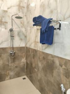 uma casa de banho com um chuveiro e toalhas azuis em Baruna Sari Villa em Ubud