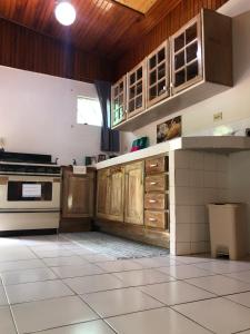 a kitchen with wooden cabinets and a tile floor at Casa El Bonito Descanso in San Vito