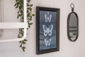 a picture of butterflies on a wall next to a mirror at Travel & Live Porto Hostel in Porto