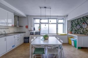 a kitchen with a white table and chairs in it at Travel & Live Porto Hostel in Porto