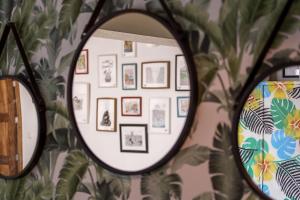 a mirror in a room with a wall of pictures at Travel & Live Porto Hostel in Porto