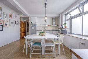 a kitchen and dining room with a white table and chairs at Travel & Live Porto Hostel in Porto