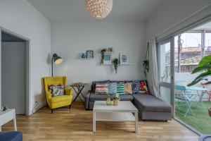 a living room with a couch and a yellow chair at Travel & Live Porto Hostel in Porto