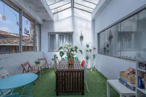 uma sala com mesas e cadeiras e uma mesa com uma planta em Travel & Live Porto Hostel no Porto