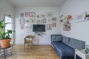 uma sala de estar com um sofá azul e uma televisão em Travel & Live Porto Hostel em Porto