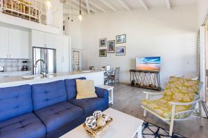 a living room with a blue couch and a kitchen at Hale Kai 220 in Kahana