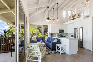a living room with a blue couch and a kitchen at Hale Kai 220 in Kahana +24 photos