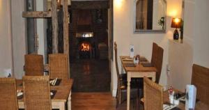a dining room with a table and a fireplace at The Bulls Head Inkberrow in Inkberrow
