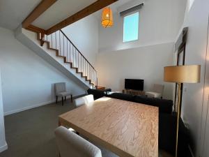 a living room with a table and a staircase at CASAS DO LARANJO- Cottages & Infinity Pool in Gaula