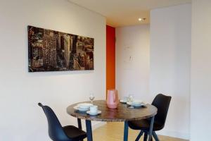 a table in a room with chairs and a painting at 902 Cityscape Loft in Bogotá