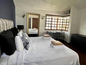 a bedroom with a white bed with two pillows on it at Beautiful Jungle House on a strategic location in Cancún
