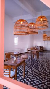 una sala da pranzo con tavoli, sedie e lampadari a braccio di Holâ Hotel a La Falda