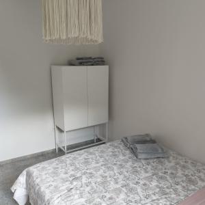 een witte kamer met een bed en een witte kast bij Apartamenty u Gołębiewskich in Stara Kamienica