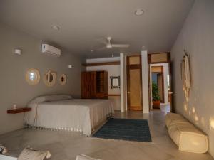 um quarto com uma cama e um sofá em Casa La Bomba em Puerto Escondido