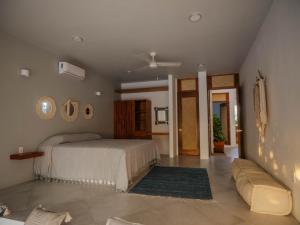a bedroom with a bed and a couch in it at Casa La Bomba in Puerto Escondido