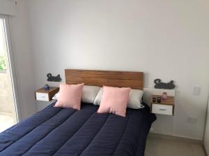 a bedroom with a bed with two pink pillows at Elio VII Suite in Cipolletti