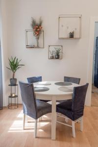 einen Esstisch mit Stühlen und eine weiße Wand in der Unterkunft Magnolia apartment in Zagreb