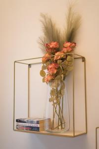 a vase with flowers on a shelf with books at Magnolia apartment in Zagreb
