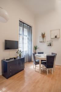 a dining room with a table and chairs and a tv at Magnolia apartment in Zagreb