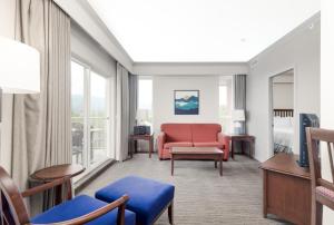 a living room with a red chair and a couch at Manteo at Eldorado Resort in Kelowna