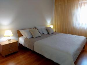 a bedroom with a large bed and a window at Apartments Tonći and Iris in Primošten