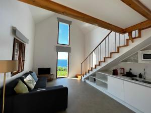 a living room with a couch and a staircase at CASAS DO LARANJO- Cottages & Infinity Pool in Gaula