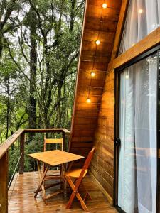 - une terrasse couverte en bois avec une table et des chaises dans l'établissement Chalé da Roça - Garibaldi, à Garibaldi