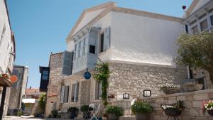a white building with plants in front of it at Zena Hotel Alaçatı Adults Only in Alaçatı