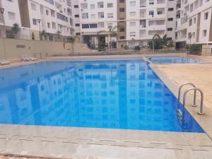 - une grande piscine d'eau bleue dans un bâtiment dans l'établissement appartement Islane G26, à Agadir