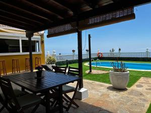 een patio met een tafel en stoelen en een zwembad bij TERRAZITA in Tijarafe