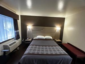 ein Hotelzimmer mit einem Bett und einem Fenster in der Unterkunft Budget Inn Nassawadox in Nassawadox