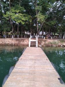 een houten brug over het water in een park bij B101 AP do Lago, com Cozinha e Churrasqueira privativa , internet banda larga, rampa barco e jet, pesqueiro in Caldas Novas