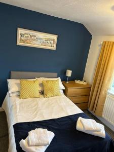 a blue bedroom with a bed with two towels on it at Entire Home in Middlesbrough