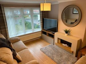 a living room with a television and a mirror at Entire Home in Middlesbrough