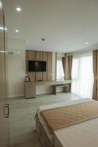 THE DECK OTEL في طرابزون: غرفة فندقية بسرير وتلفزيون بشاشة مسطحة