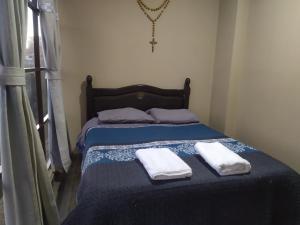 a bedroom with a bed with two towels on it at Hostal Alejandra in Sucre
