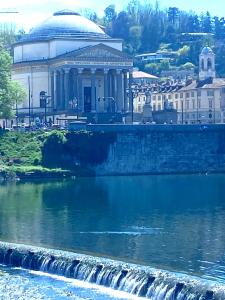 a building next to a river with a waterfall at Casa Vittorio in Turin