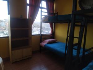 a room with a bunk bed and a window at Hostal Alejandra in Sucre