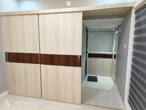 a bathroom with wooden doors and a shower stall at Peppercorn Cottage, Vythiri. in Vythiri