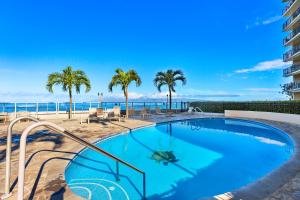 a swimming pool with a view of the ocean at Hololani B704 in Kahana