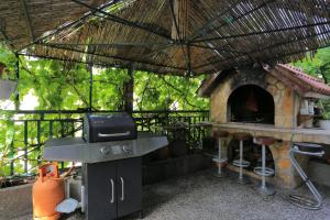 uma cozinha exterior com comodidades para churrascos e um forno exterior em Studio Gradac 2784d em Gradac