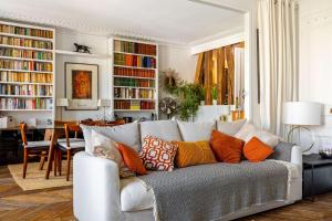 a living room with a white couch with colorful pillows at GuestReady - Gorgeous Clementine Family Flat in Le Marais in Paris