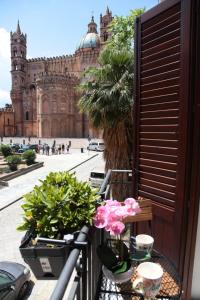 a balcony with flowers and a building in the background at Alle Absidi della Cattedrale in Palermo