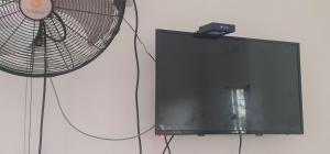 uma televisão de ecrã plano com uma ventoinha ao lado em El Rincon em Cahuita