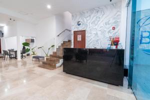 a lobby with a staircase and a table and chairs at Hotel Pacific Blue Mazatlan in Mazatlán